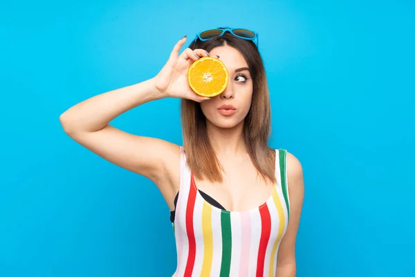 Mujer Joven Vacaciones Verano Sobre Fondo Azul Sosteniendo Una Naranja —  Fotos de Stock