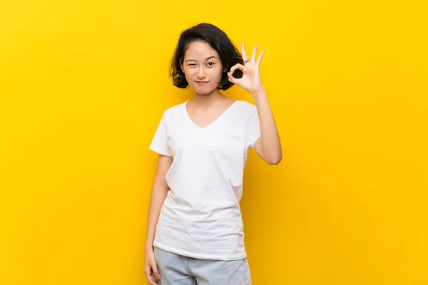 Asiática Joven Mujer Sobre Aislado Amarillo Pared Mostrando Signo Con —  Fotos de Stock