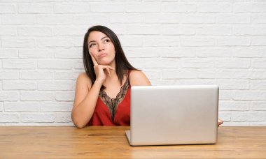 Bir dizüstü bilgisayar ile genç Meksikalı kadın bir fikir düşünme