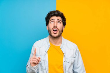 Izole renkli arka plan üzerinde Yakışıklı işaret ve şaşırttı