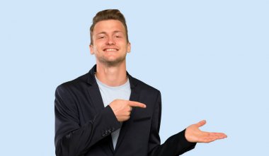 Sarışın yakışıklı adam bir reklam eklemek için avuç üzerinde copyspace hayali tutan