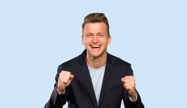 Sarışın yakışıklı adam kazanan pozisyonda bir zafer kutluyor