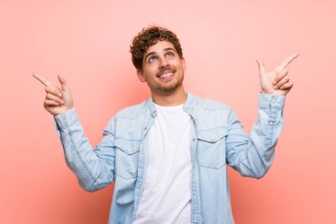 İşaret parmağı ile işaret pembe duvar üzerinde Blonde adam harika bir fikir
