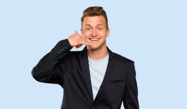 Sarışın yakışıklı adam telefon jesti yapıyor. Beni geri arayın işareti