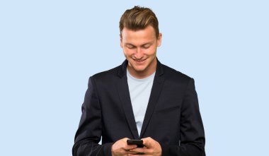 Sarışın yakışıklı adam cep ile bir mesaj gönderme