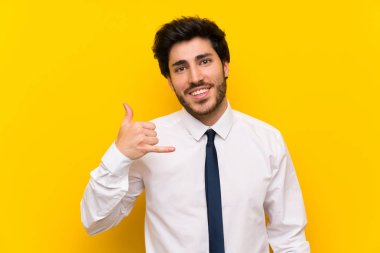 İzole sarı arka plan üzerinde telefon jestyapma Işadamı