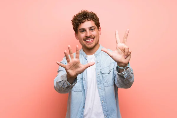 Blonder Mann Über Rosa Wand Der Mit Fingern Acht Zählt — Stockfoto