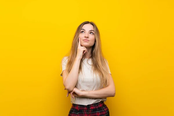 Mujer Joven Sobre Aislada Pared Amarilla Pensando Una Idea —  Fotos de Stock