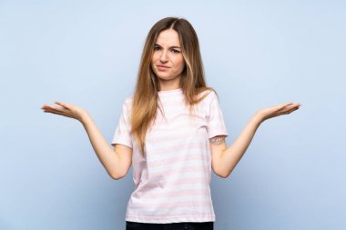 Izole mavi arka plan üzerinde genç kadın bir şey anlamak için mutsuz