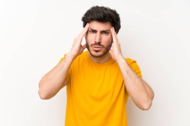 Izole beyaz duvar üzerinde yakışıklı mutsuz ve bir şey ile sinirli. Negatif yüz ifadesi