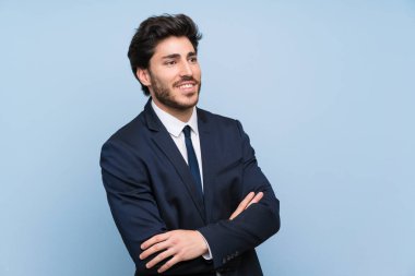 Izole mavi duvar üzerinde Işadamı mutlu ve gülümseyen