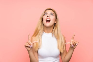 İzole edilmiş pembe arka planda genç bir kız işaret parmağıyla işaret etmek harika bir fikir.