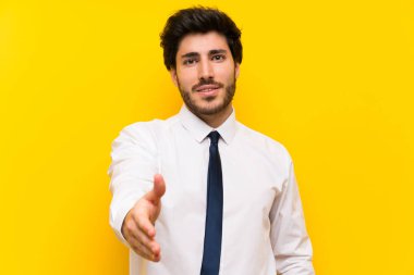 İşadamı iyi bir anlaşma dan sonra izole sarı arka plan handshake