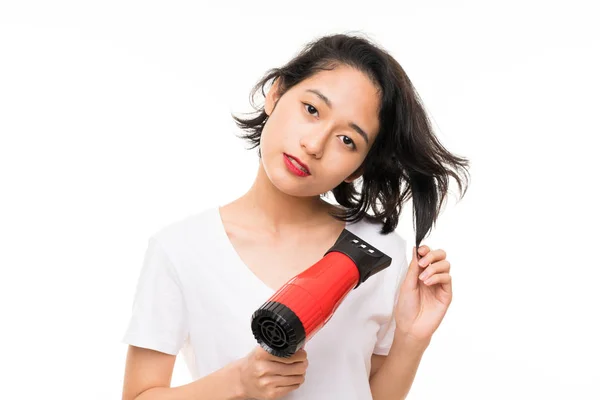 亚洲年轻女子在孤立的背景与吹风机 — 图库照片