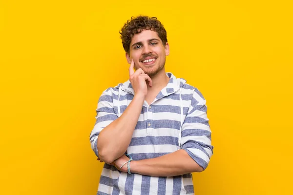 Blonde Man Gele Muur Denken Een Idee Tijdens Het Opzoeken — Stockfoto