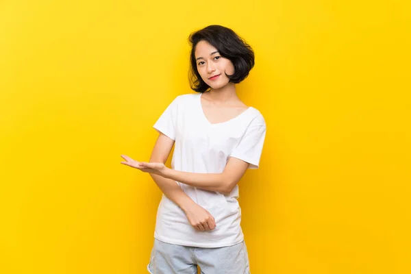 Asiática Joven Mujer Sobre Aislado Amarillo Pared Presentando Una Idea —  Fotos de Stock