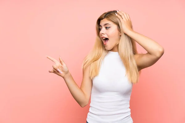 Adolescente Chica Sobre Aislado Rosa Fondo Sorprendido Señalando Dedo Lado —  Fotos de Stock