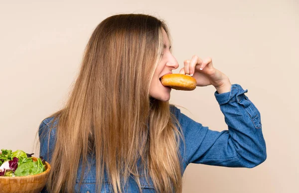 Izole Arka Plan Üzerinde Salata Ile Genç Kadın Bir Donut — Stok fotoğraf