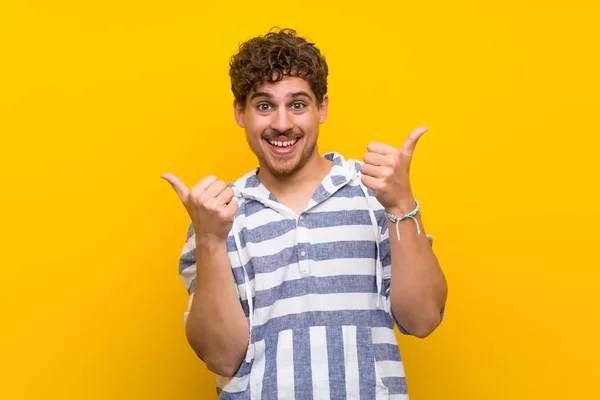 Blonde Man Yellow Wall Giving Thumbs Gesture Both Hands Smiling — Stock Photo, Image