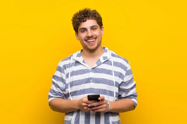 Blonder Mann Über Gelbe Wand Sendet Eine Nachricht Mit Dem — Stockfoto