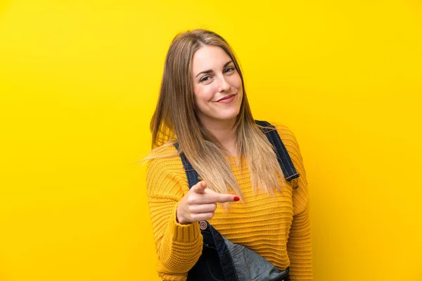 Donna Con Tuta Sopra Isolato Muro Giallo Punta Dito Contro — Foto Stock