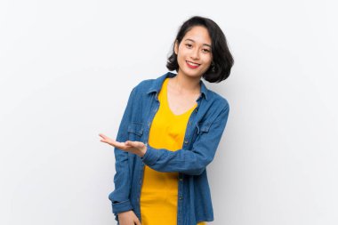 Asyalı genç kadın izole beyaz arka plan üzerinde doğru gülümseyerek bakarken bir fikir sunan