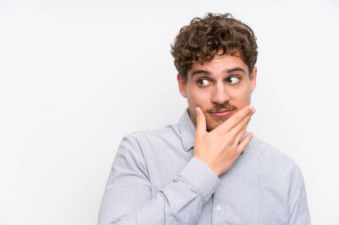 Sarışın adam bir fikir düşünce izole beyaz duvar üzerinde