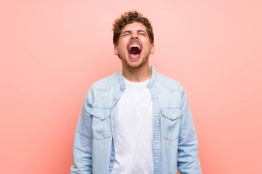 Ağzı tamamen açık ön bağırarak pembe duvar üzerinde Sarışın adam
