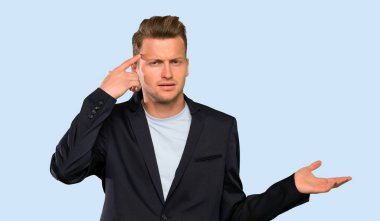 Sarışın yakışıklı adam kafasına parmak koyarak delilik jest yapma