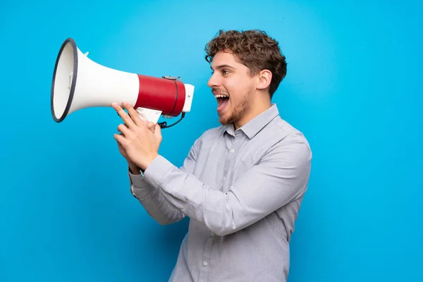 Blonde Man Blauwe Muur Schreeuwen Door Een Megafoon — Stockfoto