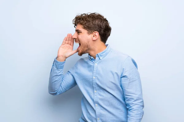 Blonde Man Blue Wall Shouting Mouth Wide Open Lateral — Stock Photo, Image