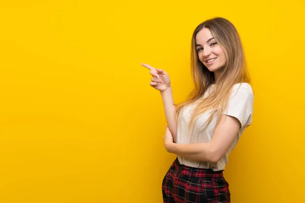 Mujer Joven Sobre Pared Amarilla Aislada Señalando Dedo Hacia Lado — Foto de Stock