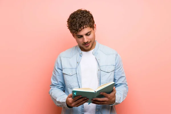 Hombre Rubio Sobre Pared Rosa Sosteniendo Libro Disfrutando Lectura —  Fotos de Stock