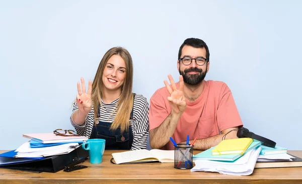 Students with many books happy and counting three with fingers