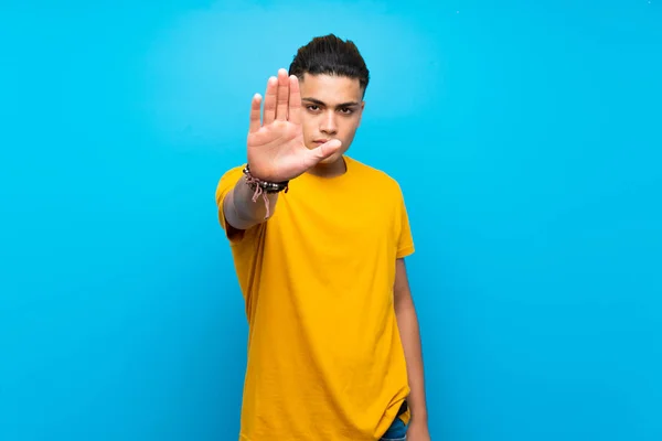 Young Man Yellow Shirt Isolated Blue Background Making Stop Gesture — Stockfoto