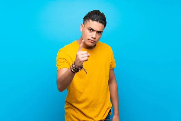 Young Man Yellow Shirt Isolated Blue Background Frustrated Pointing Front — Stock Photo, Image