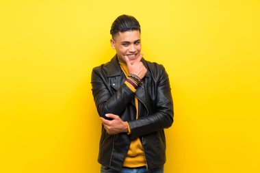 Young man over isolated yellow background looking to the side