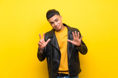 Young man over isolated yellow background counting eight with fingers