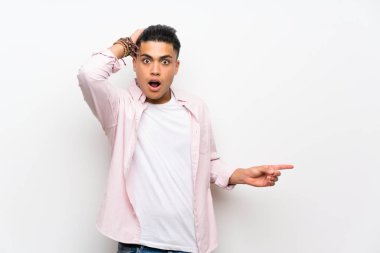 İzole edilmiş beyaz duvarın üzerindeki genç adam şaşırdı ve parmağını yana çevirdi.