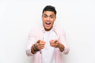 Izole beyaz duvar üzerinde genç adam size parmak
