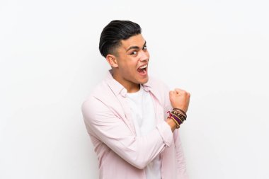 Genç adam bir zaferini kutluyor izole beyaz duvar üzerinde