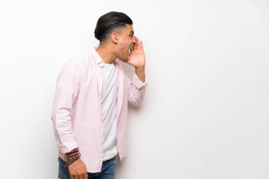 Ağzı tamamen açık bağıran izole beyaz duvar üzerinde genç adam