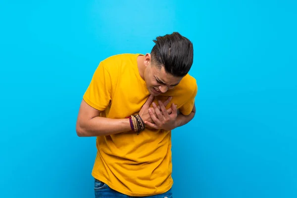 Young Man Yellow Shirt Isolated Blue Background Having Pain Heart — Stok fotoğraf