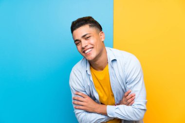 Izole renkli arka plan gülen üzerinde genç adam