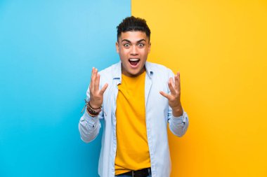 Sürpriz yüz ifadesi ile izole renkli arka plan üzerinde genç adam