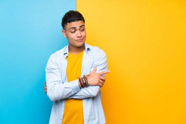 Izole renkli arka plan üzerinde genç adam bir fikir düşünme