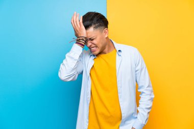 Izole renkli arka plan üzerinde genç adam yüz ifadesi karıştırarak şüpheleri olan