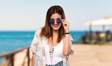 Gözlük ile yaz tatillerinde bikinili genç kadın ve plajda sürpriz