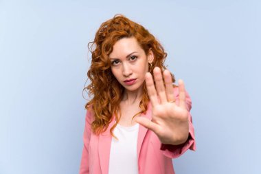 Izole mavi duvar üzerinde takım elbiseli Redhead kadın stop jest yapma
