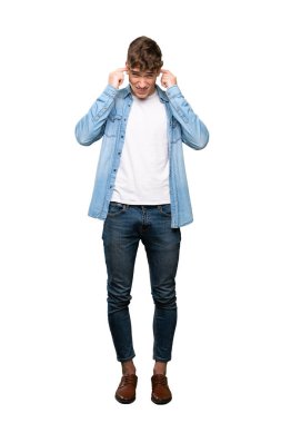 Yakışıklı bir genç adam tam uzunlukta bir çekim sinirli ve izole beyaz arka plan üzerinde kulakları kapsayan